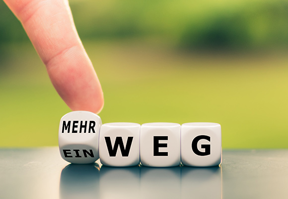 Wende: Mann dreht Würfel von Ein- zu Mehrweg