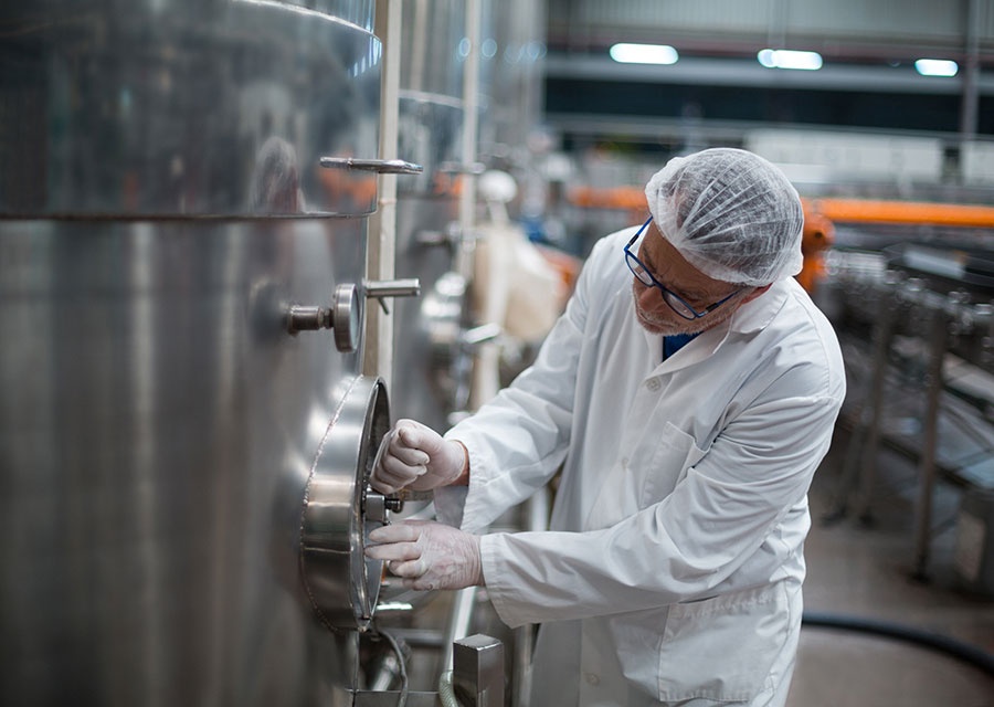 Wie vegane Getränkeherstellung funktioniert (1) Mitarbeiter in der Getränkeproduktion bei der Qualitätskontrolle