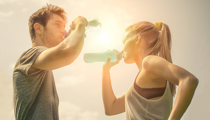 Getränke beim Sport (3) Paar bei der Trinkpause mit Wasser und POWERADE