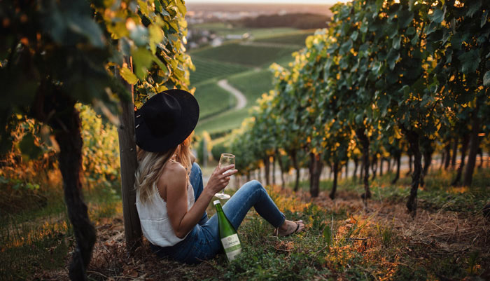 Jetzt ist Federweißer-Zeit (0) Frau sitzt auf einem Weinberg - mit Federweißer gewappnet