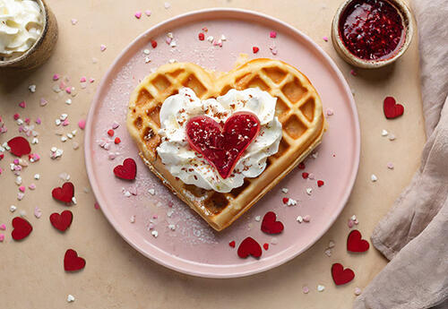 Fluffige Waffeln mit Mineralwasser in Herzchenform. Dazu etwas Eierlikörsahne und herzliche Deko – schon ist dir der Erfolg sicher!