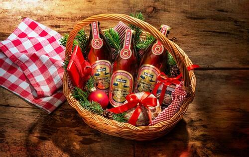 Hübsch im Körbchen als Geschenk präsentiert: einige Flaschen Tucher Christkindlesmarkt Bier.
