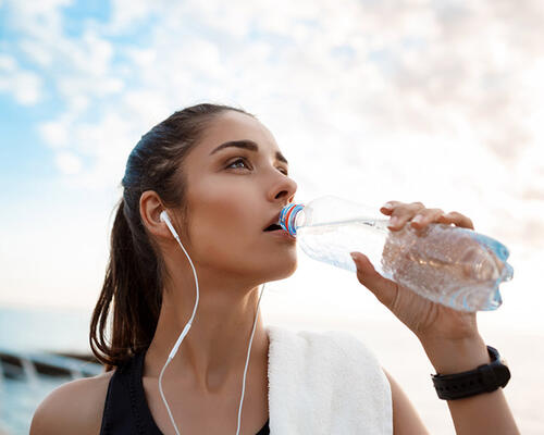 Sportlerin trinkt Mineralwasser