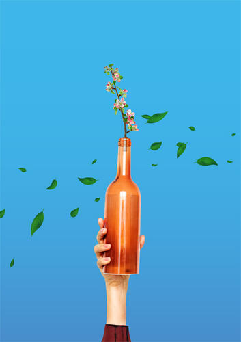 Hand hält Flasche mit vielen Blumen