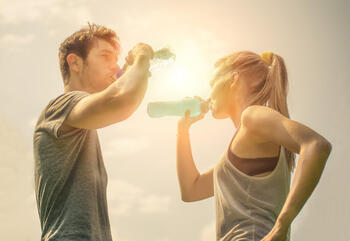 Paar bei der Trinkpause mit Wasser und POWERADE